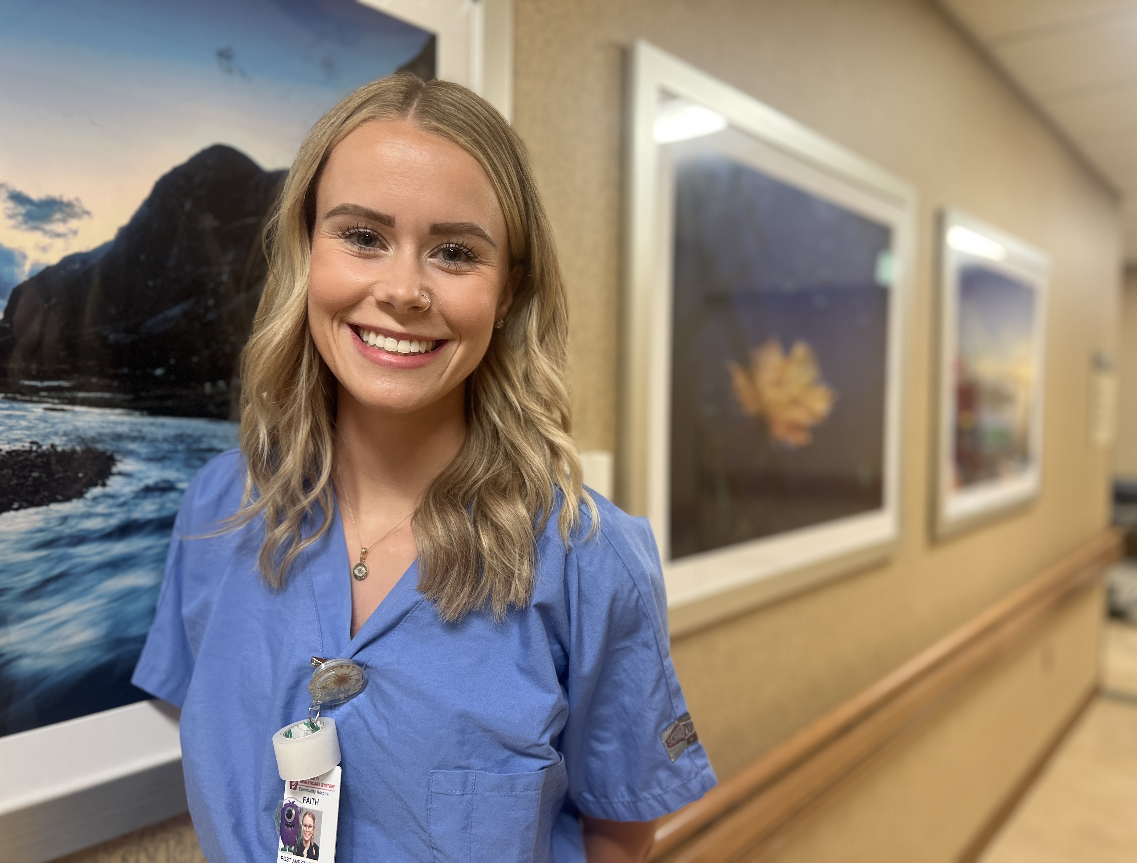 Faith Mikolajczyk standing in front of a picture in a hallway